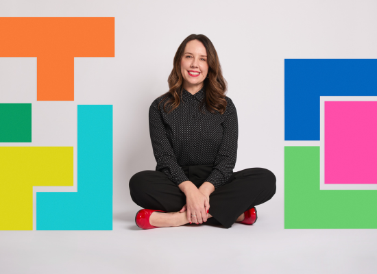 Woman in black with red shoes, geometric shapes backdrop